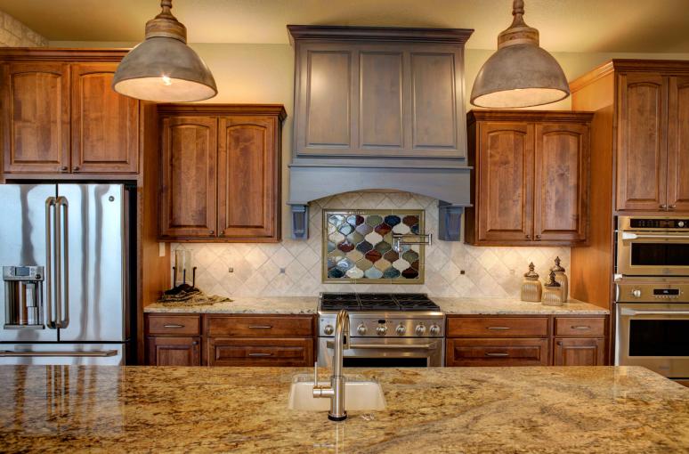 The kitchen has customized stained alder cabinets with leather finished granite.